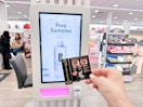 Hand holding a small sample in front of a kiosk at Ulta 