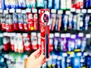 Colgate Optic White Charcoal Toothbrush held up in front of other brushes in oral aisle at Walmart