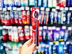 Colgate Optic White Charcoal Toothbrush held up in front of other brushes in oral aisle at Walmart