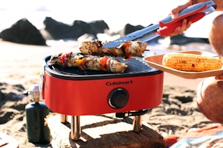 someone using the cuisinart portable grill at the beach