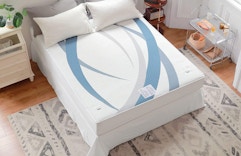 a mattress pad on a bed in a room