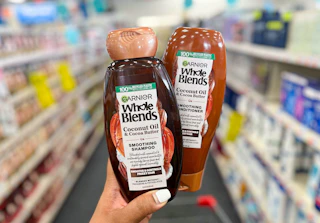 hand holding two bottles of Garnier Whole Blends