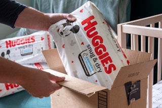 a person taking huggies diapers out of an amazon box