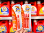 hand holding two packages of Tide To Go pens