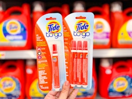 hand holding two packages of Tide To Go pens
