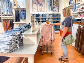 a woman shopping in american eagle looking a sweatshirts