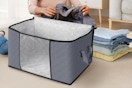 a person folding clothes into a storage bag