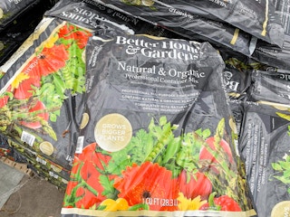 better homes and gardens natural and organic potting soil stacked up on ground