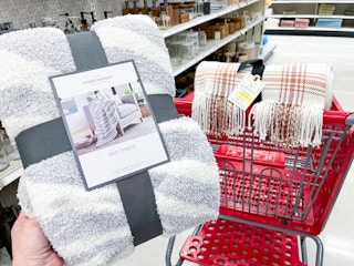 hand holding a threshold throw blanket in front of a target cart