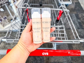 hand holding nexxus dry shampoo over a cvs cart