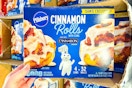 hand holding a box of pillsbury cinnamon rolls