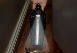someone using handheld vacuum with LED light on