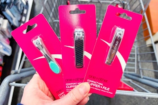 person holding 3 pairs of nail clippers over a cart