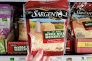 hand holding a bag of sargento cheese