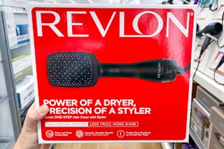 Woman holding box of Revlon one-step hair dryer.