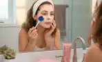 a woman applying a face mask