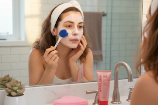 a woman applying a face mask
