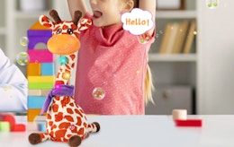 a talking giraffe on a table in front of a little girl 