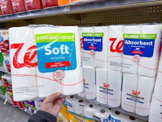 hand holding walgreens brand toilet paper and paper towels on shelf