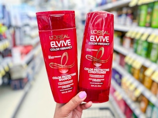 hand holding two bottles of L'Oreal Elvive shampoo and conditioner