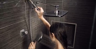 a woman using a rain and handheld showerhead