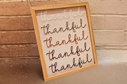 Lifestyle image of the 8x10 Way to Celebrate Thankful decor with brick wall in the background