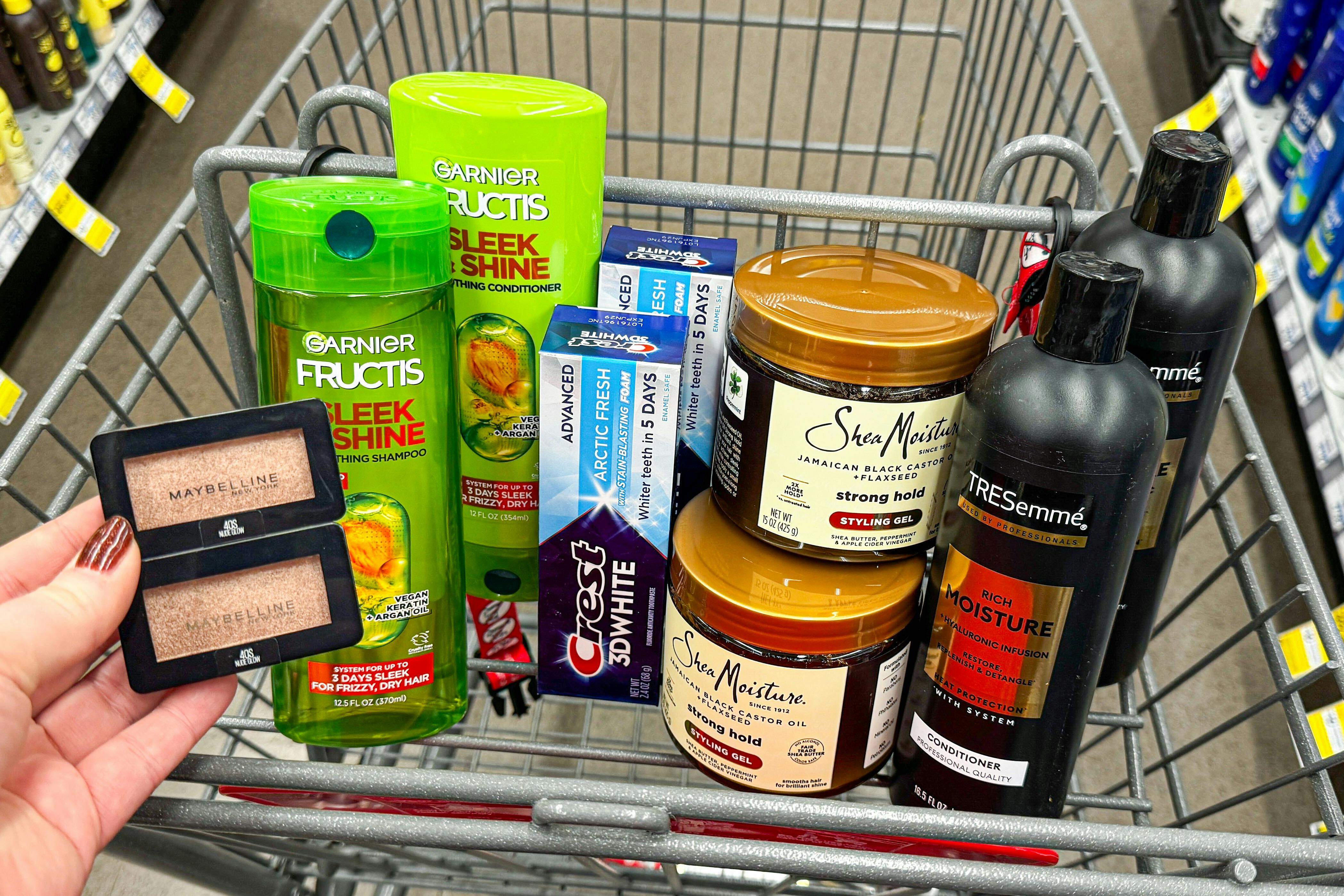 maybelline eyeshadow, garnier shampoo, crest toothpaste, shea moisture hair gel, and tresemme shampoo in a cart
