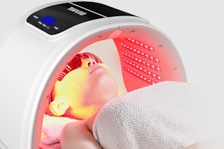 a woman using a red light therapy mask