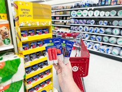 hand holding 2 nivea lip packs in front of target display