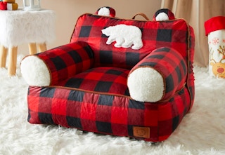 A red buffalo plaid bean bag chair with a furry bear on it