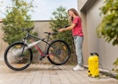 a person pressure washing a bike outside
