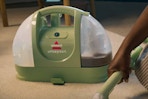 BISSELL Little Green Multi-Purpose Portable Carpet and Upholstery Cleaner being used on carpets.