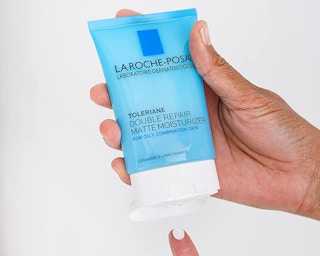 hand dispensing la roche posay double repair matte moisturizer onto their finger
