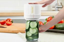 person using mason jar vacuum kit in kitchen