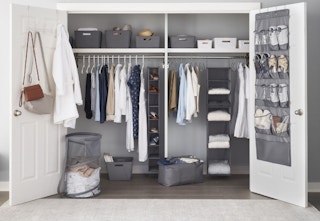 an organized closet containing bins, baskets, hampers and more