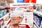 hand holding a hamilton beach hand mixer in a target aisle