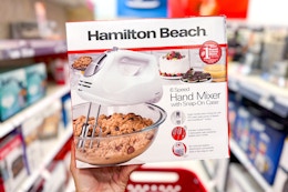 hand holding a hamilton beach hand mixer in a target aisle