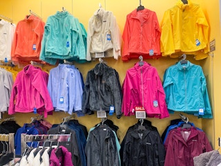 A variety of women's Columbia jackets hanging from store racks.