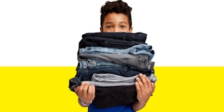 A boy carrying a pile of jeans