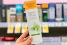hand holding burts bees toothpaste in walgreens