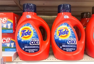 two large bottles of tide ultra oxi liquid laundry detergent on a shelf