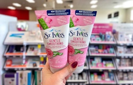 hand holding two st ives cleansers
