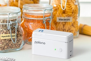 a label maker on a counter with labeled jar full of food