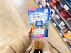 hand holding purina dentalife dog treats in walmart aisle