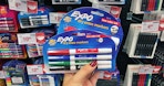 hand holding expo dry erase markers at staples
