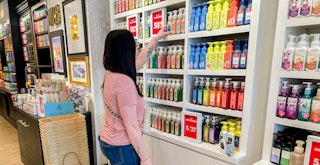 A woman looking at products in a Bath and Body Works store.