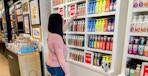 A woman looking at products in a Bath and Body Works store.