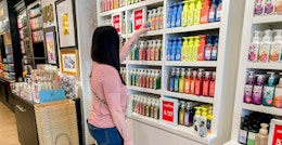 A woman looking at products in a Bath and Body Works store.
