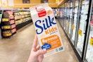 hand holding a carton of silk kids oat milk