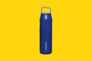 a stanley water bottle on a yellow background